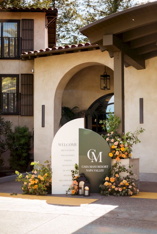 Entrance to a charming villa with arched doorway, potted flowers, and a sign for Casa Kerr Valley wine villa, welcoming visitors.
