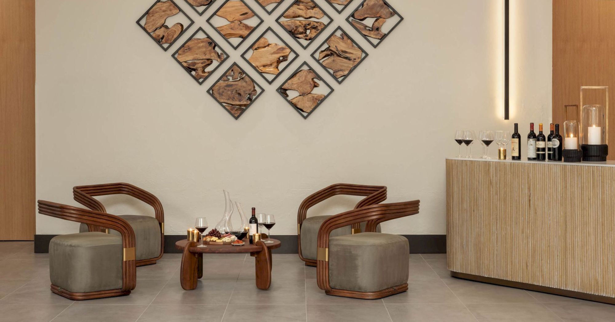A chic wine bar lounge with upholstered chairs, a small table with drinks, and diamond wall art featuring rustic wood slices.