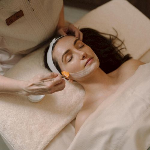 A person lying down on a bed, receiving a spa treatment.